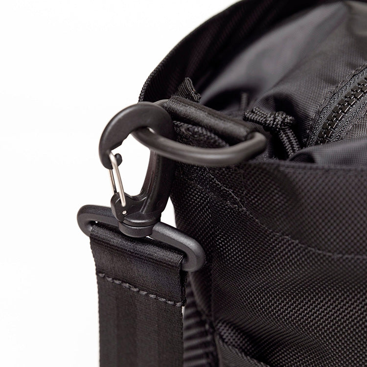 Close-up of a black New Era gym tote bag with a detachable shoulder strap attached by a swivel snap hook and D-ring.