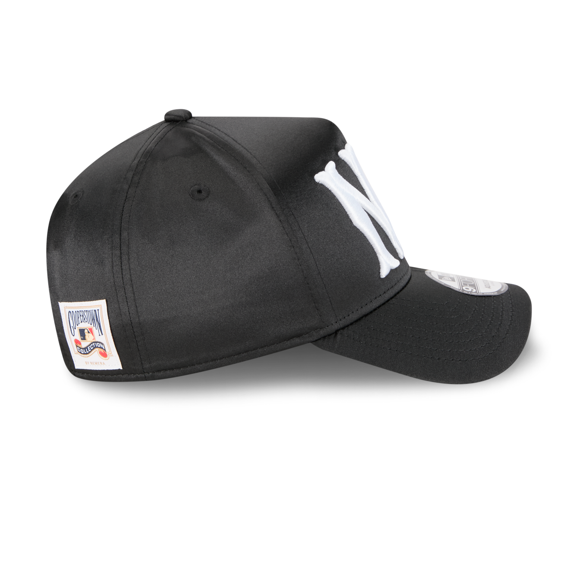 A black baseball cap with a large white embroidered 'NY' logo on the front and a small rectangular brand patch on the side, shown on a clean white background.
