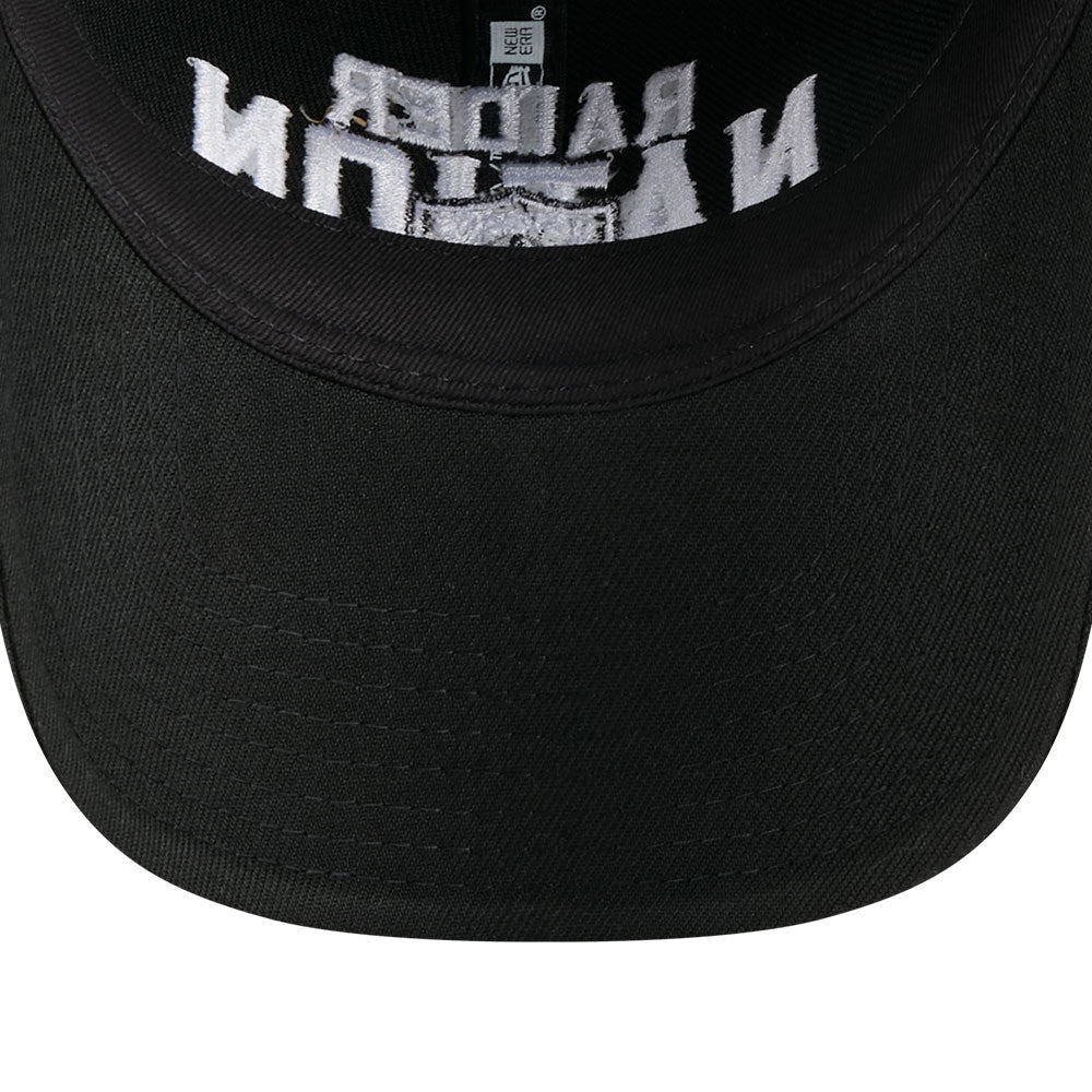 Close-up of a black baseball cap showing the inner crown with white embroidered text and a small white square logo patch.