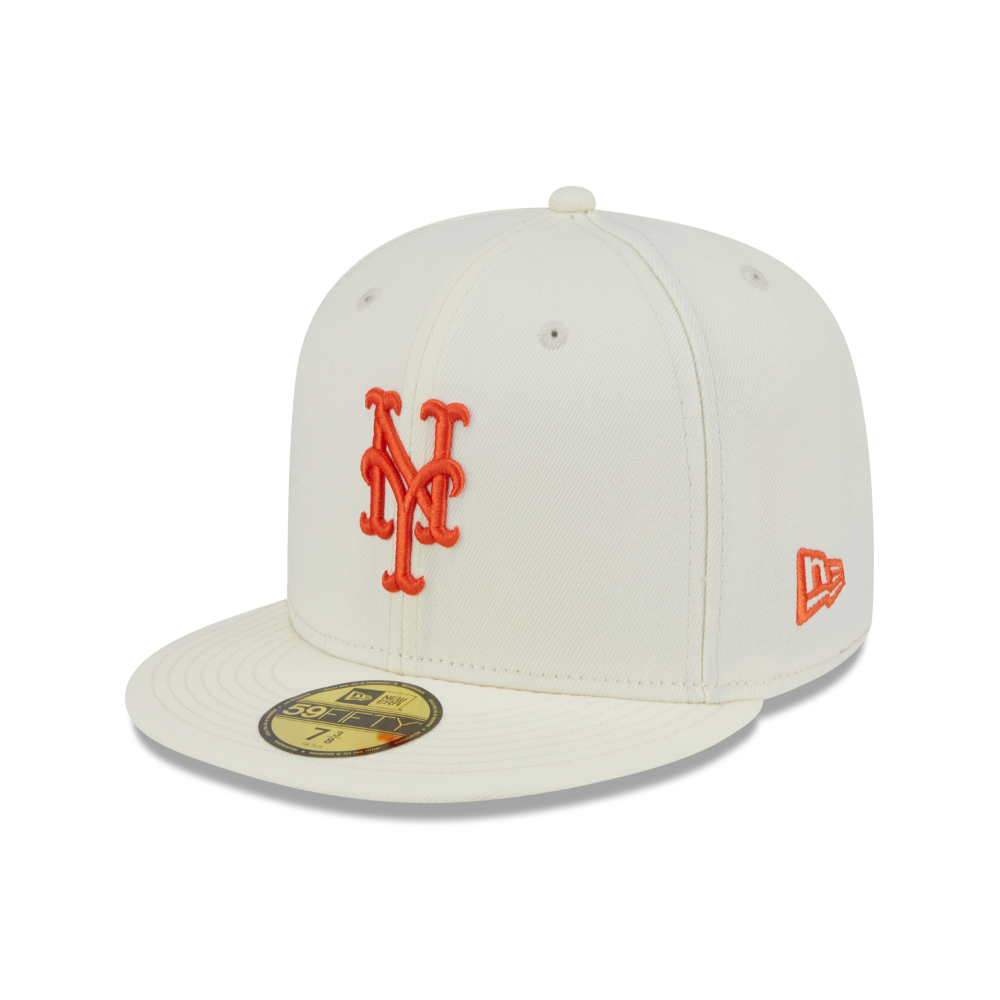 An off-white New York Mets fitted baseball cap by New Era, featuring an orange embroidered 'NY' logo on the front and an orange New Era flag logo on the side. A gold and black 59FIFTY sticker is visible on the brim.