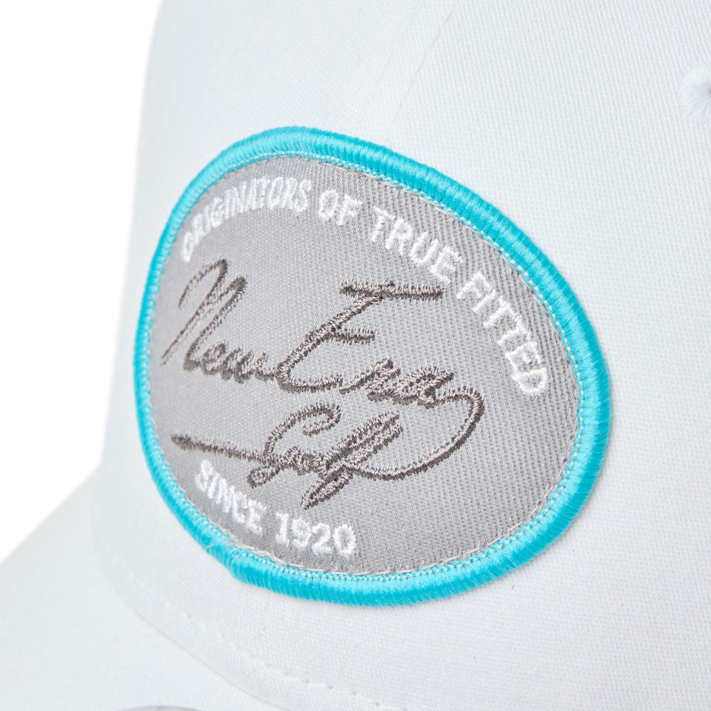 Close-up of a logo patch of new era script oval patch white golf 9seventy stretch snapback cap