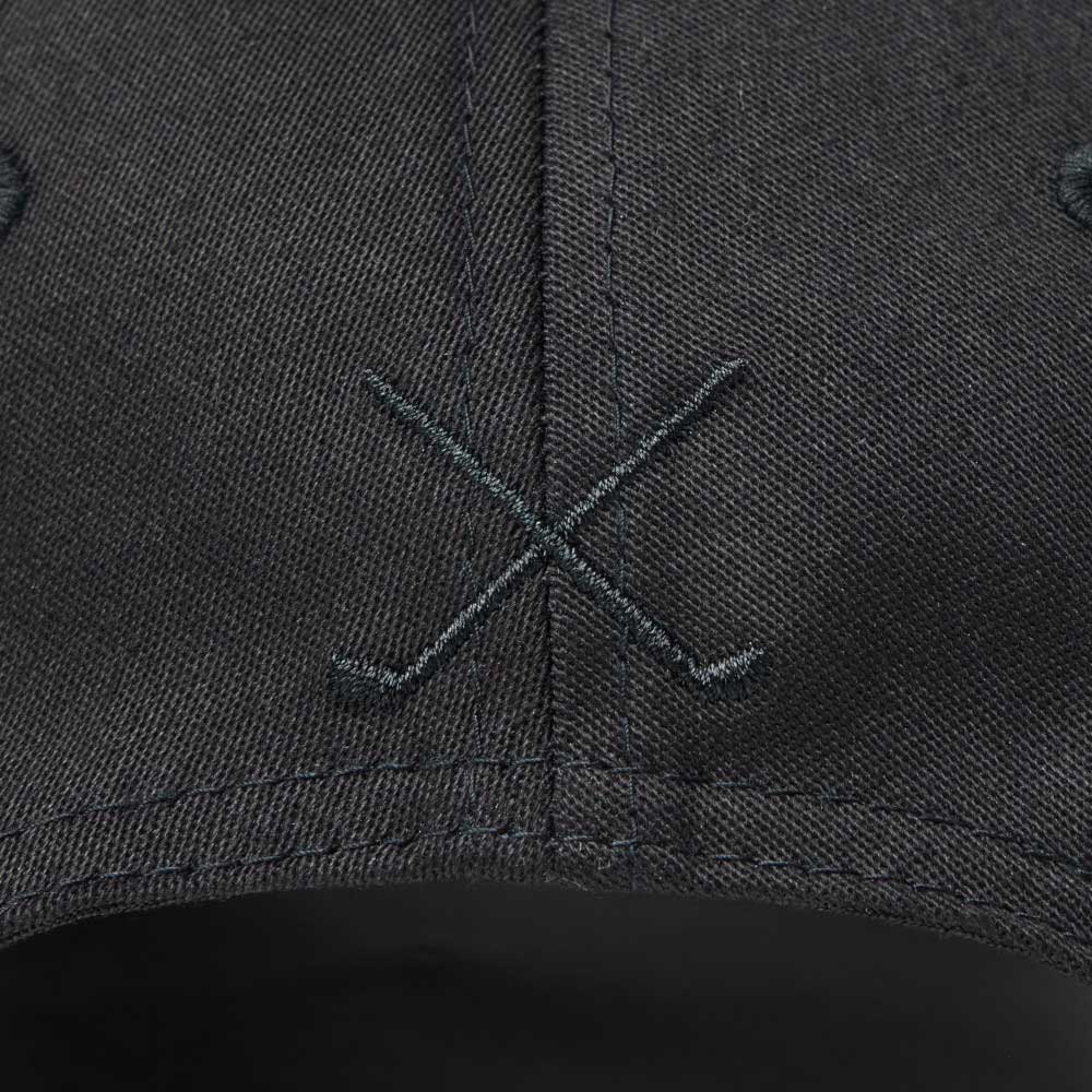 Close-up of embroidery on the back of new era script oval patch black golf 9seventy stretch snapback cap