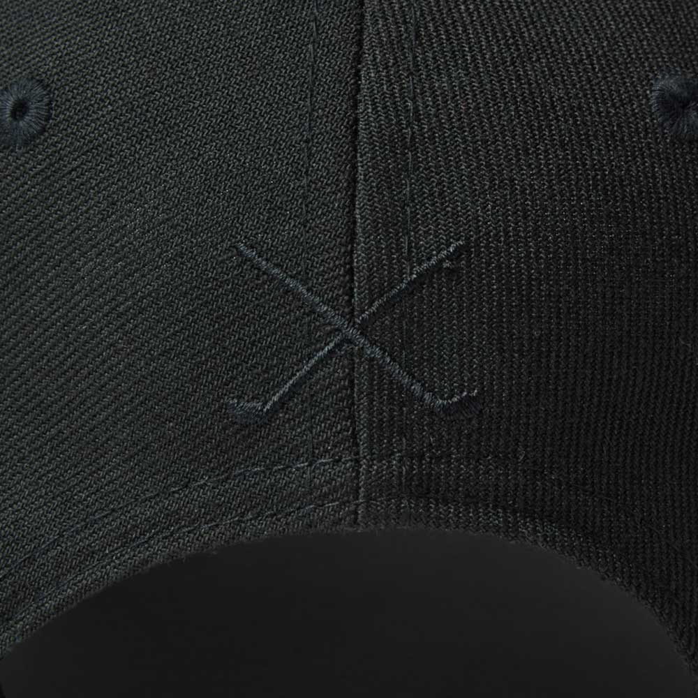 Close-up of new era wordmark golf stencil logo black 9fifty snapback cap with a subtle logo on the brim.