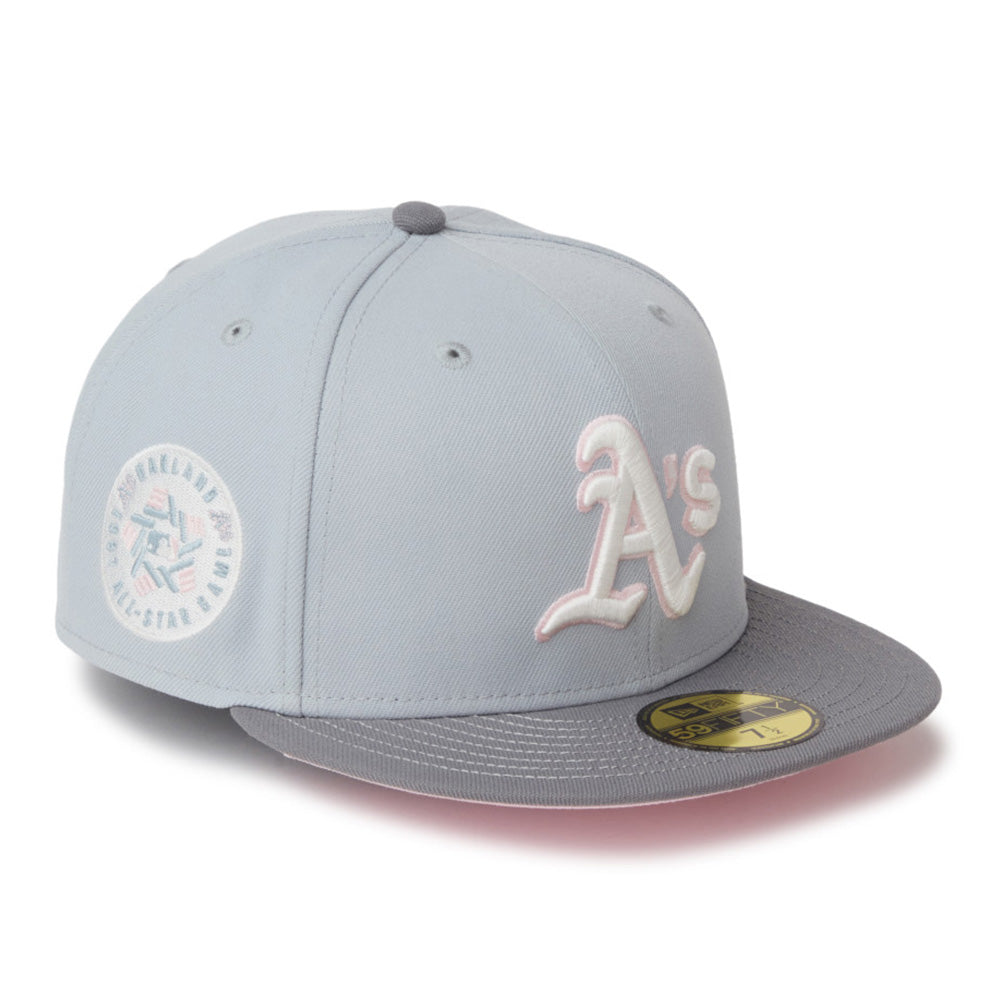 A light gray Oakland Athletics baseball cap with a gray flat brim, featuring a white and pink embroidered 'A's' logo on the front and a circular All-Star Game patch on the side. A gold New Era 50FIFTY sticker is visible on the brim.