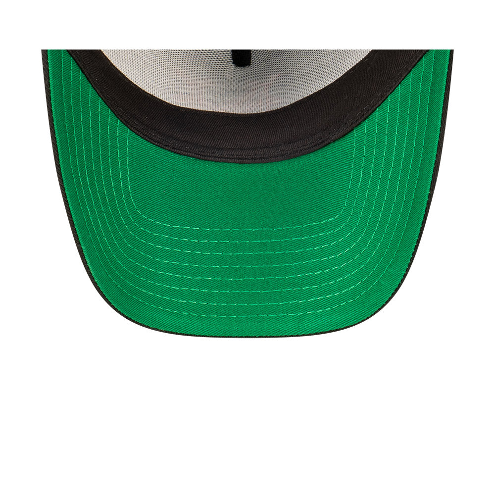 Close-up of a green baseball cap with a black rim on a white background