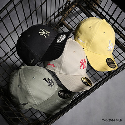 Four caps with 'NY' and 'LA' logos on a shopping cart