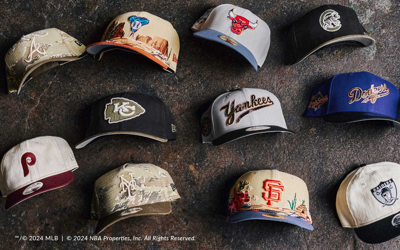 Collection of various baseball caps with different team logos on a dark surface.